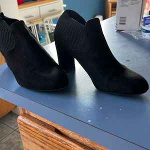 Black high heeled soft suede type material.  Flexible ankle area.  2.5-3” heel